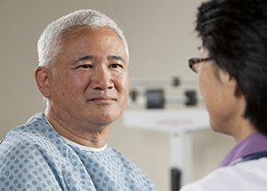 Man talking to healthcare provider in exam room.