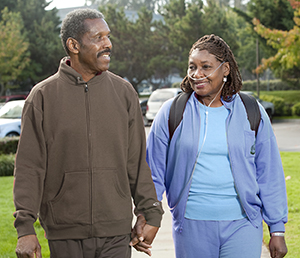 Woman wearing nasal cannula walking outdoors with man.